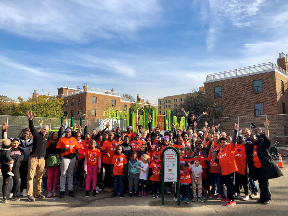 Residents and partners cheering at the newly built playground in Queens