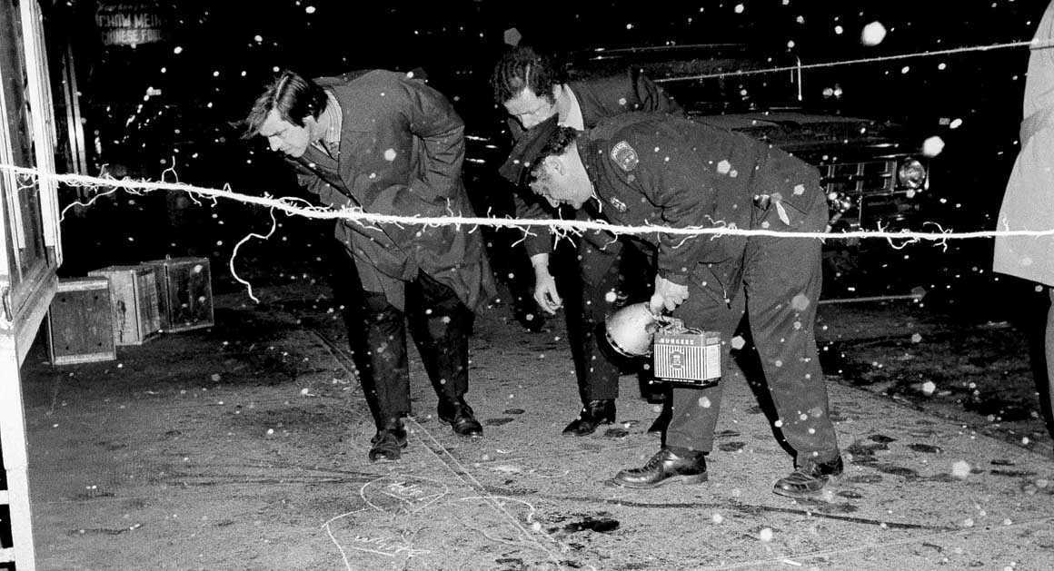 Detectives investigating the murders, looking at the blood-spattered sidewalk