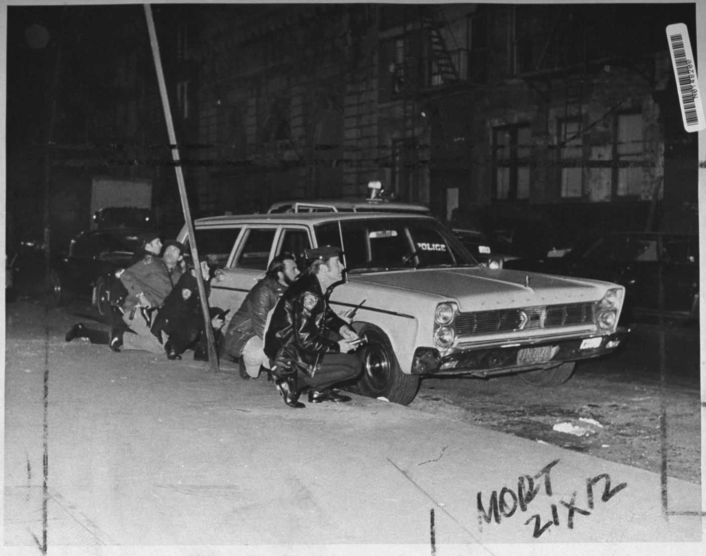 Police officers behind a car near the crime scene