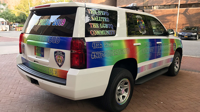 A police SUV covered in rainbow messaging celebrating World Pride Month and the LGBTQ community