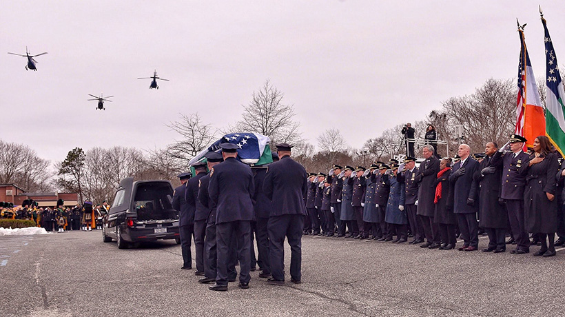 Mayor, Public Advocate, Police Commissioner in front of a flag-draged casket