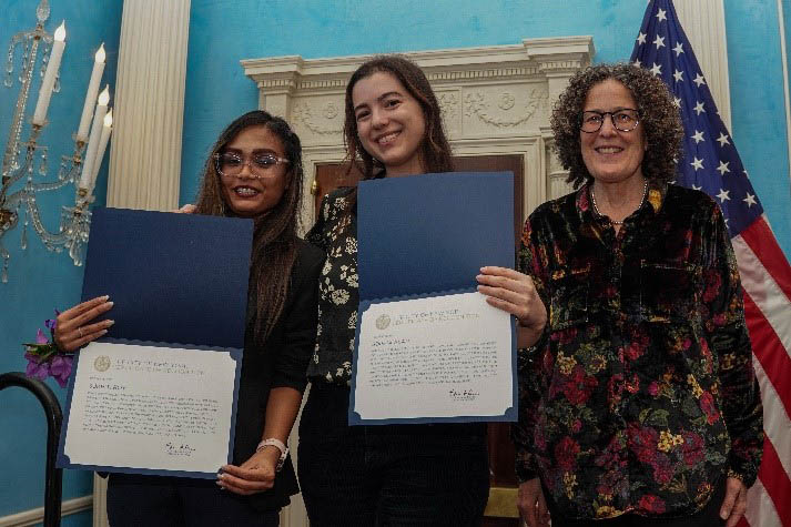 Three women holding certificates