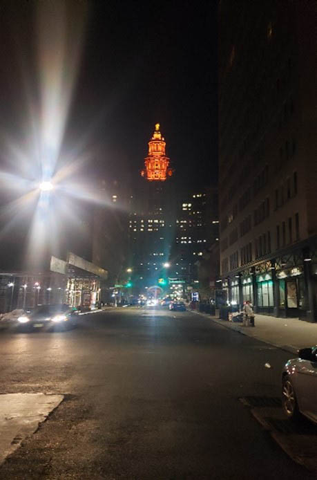 Outside view of David N. Dinkins Municipal Building illuminated in orange lights.