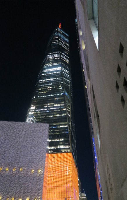 Outside view of One World Trade Center Building illuminated in orange lights.