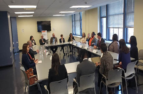 Large conference room with 20+ people seated and engaged in discussion