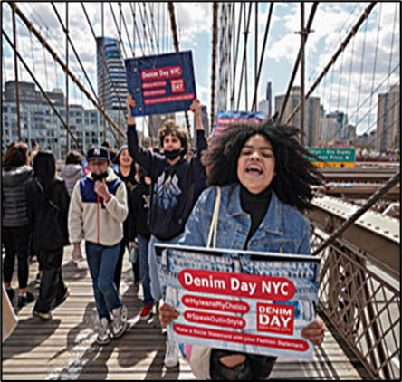 Denim Day demonstration with protesters in New York City on Brooklyn bridge with protests holding signs and chanting.