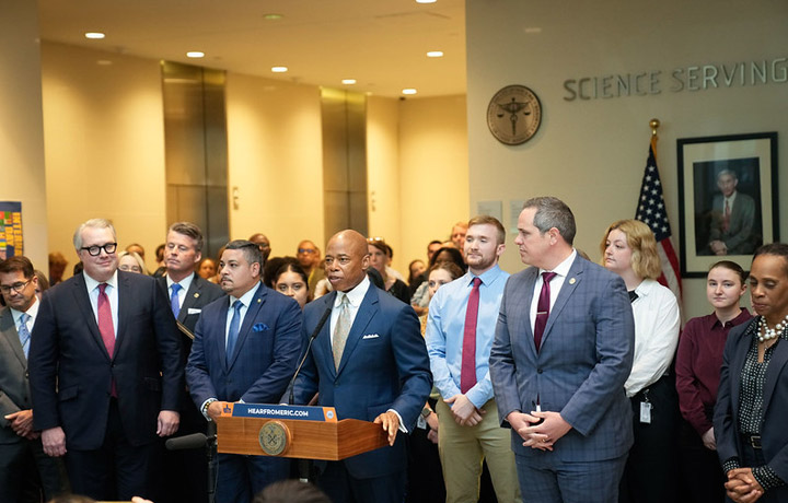 mayor adam and o c m e are seen giving a press briefing
                                           