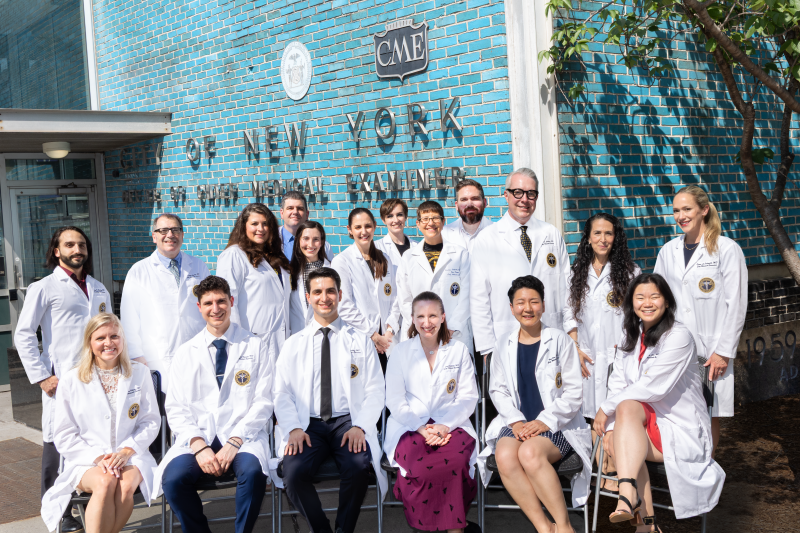 The full staff of nearly 20 New York City medical examiners pose in doctors’ coats for their annual photo outside the Manhattan headquarters building. 