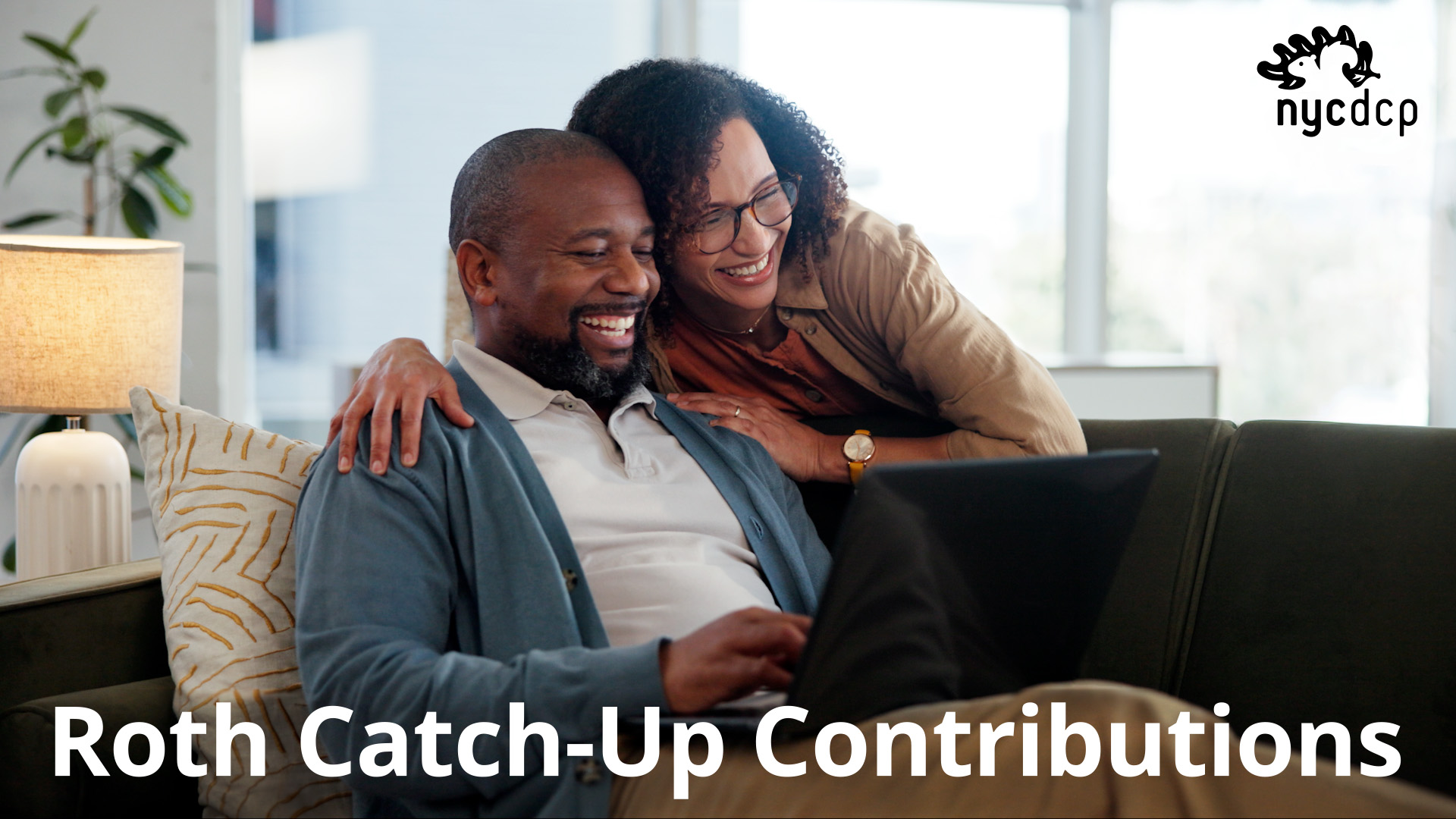 Two people smiling, looking at a laptop