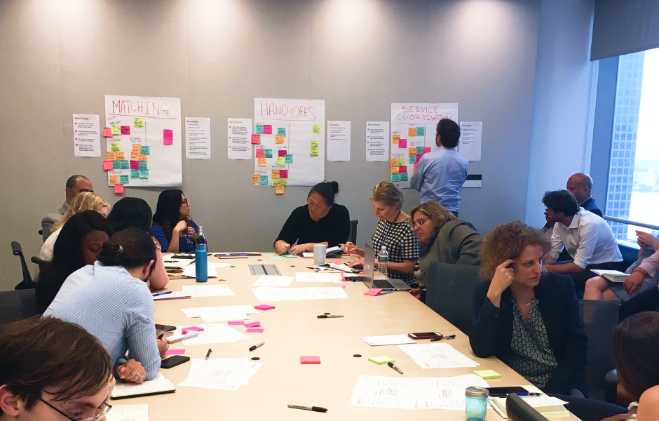 Groups of city workers speaking and writing notes on improving service coordination.