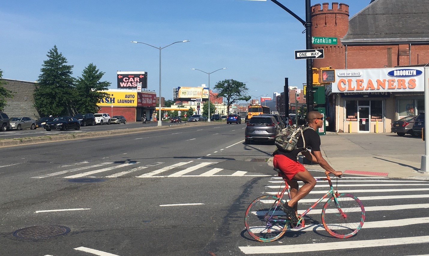 A person rides a bicycle at Franklin and Atlantic Avenues.
