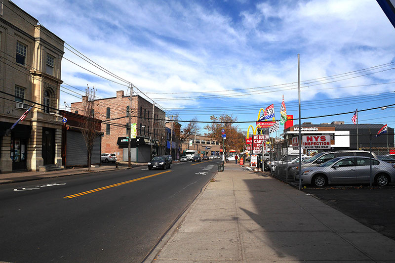 Small buildings and a car dealership line Bay Street.