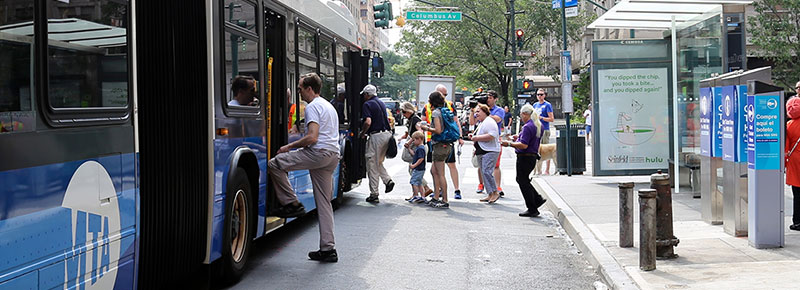 People waiting in line to board a bus.