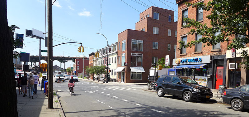 Pedestrian view of a road with a cyclist and cars