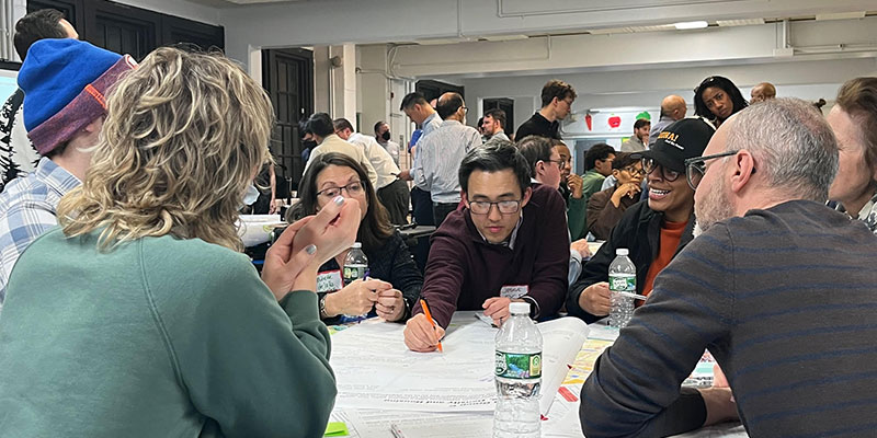 Group of people sitting at a table looking at some documents
