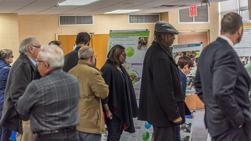 People in a large room looking at posters.