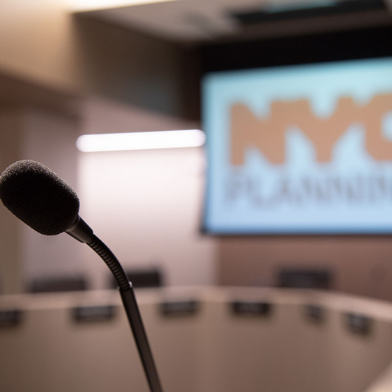 Microphone in front of a screen Text reads "NYC"