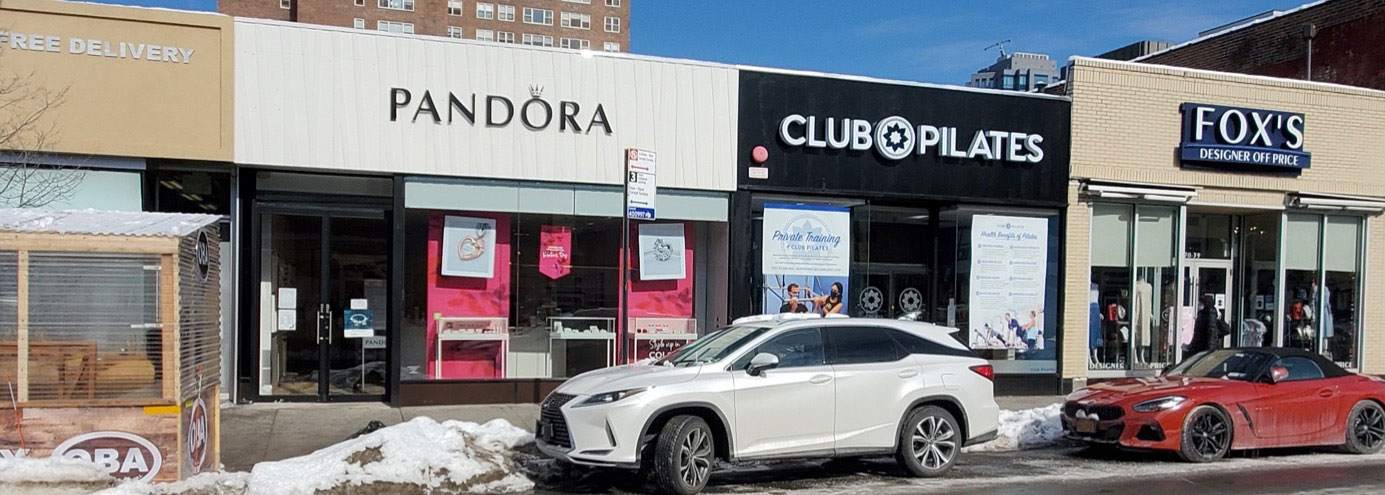 Three storefronts: a jewelry store, a Pilates gym, and a clothing store. 