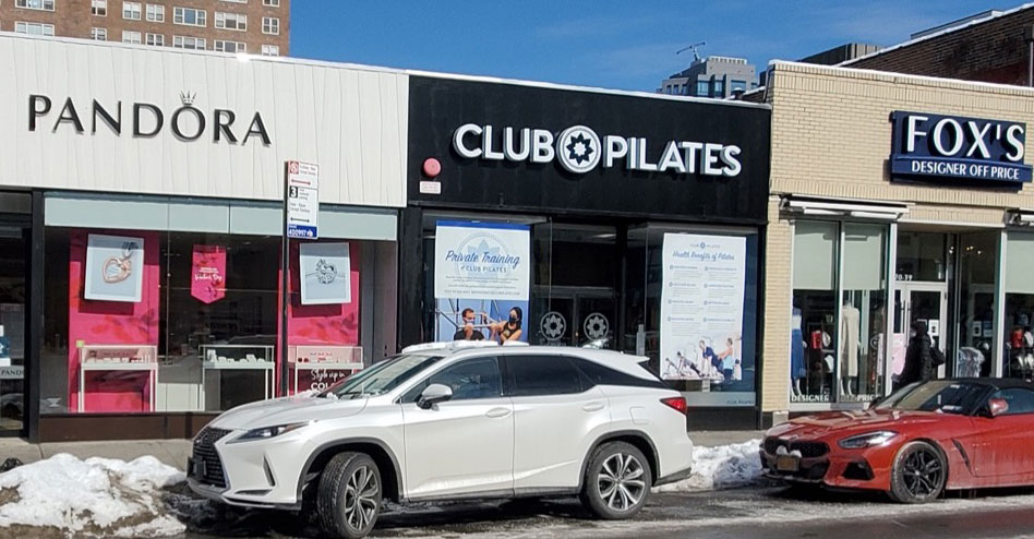 Three storefronts: a jewelry store, a Pilates gym, and a clothing store.