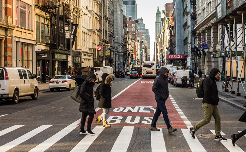 Soho/Noho Neighborh Plan -Streetscape with storefronts and people crossing a crosswalk