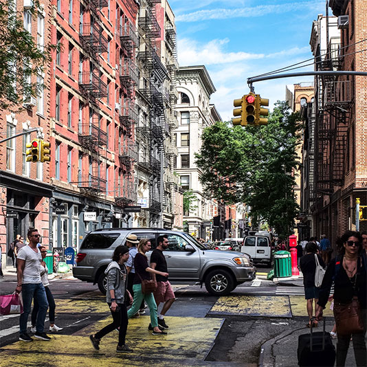 People in a crosswalk with buildings in the background