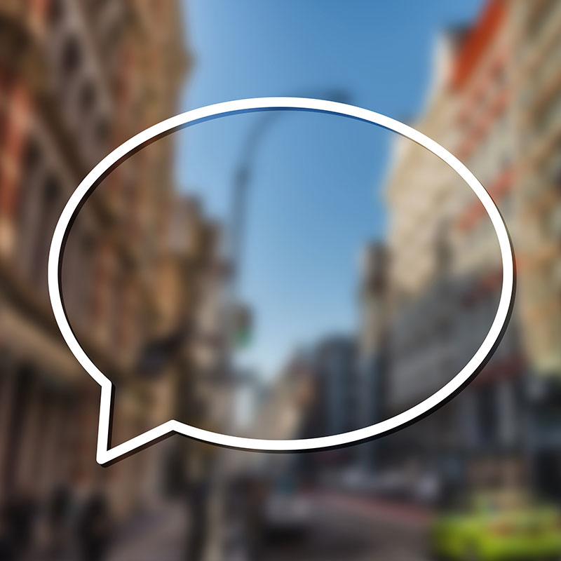 Speech bubble over a blurred streetscape