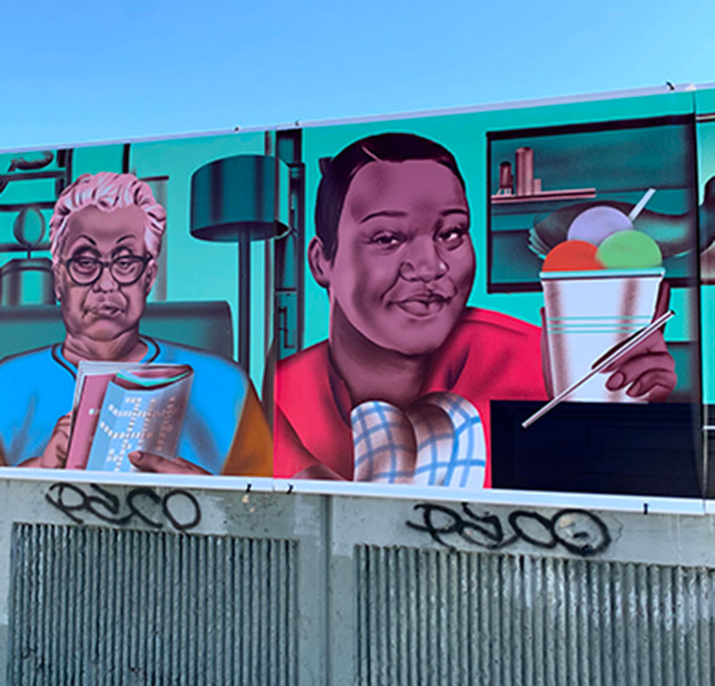 Mural of a person reading and another enjoying a beverage