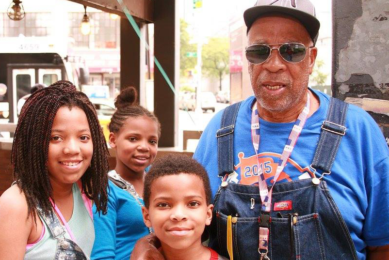 older man with sunglasses posing with two girls and one boy for a photo