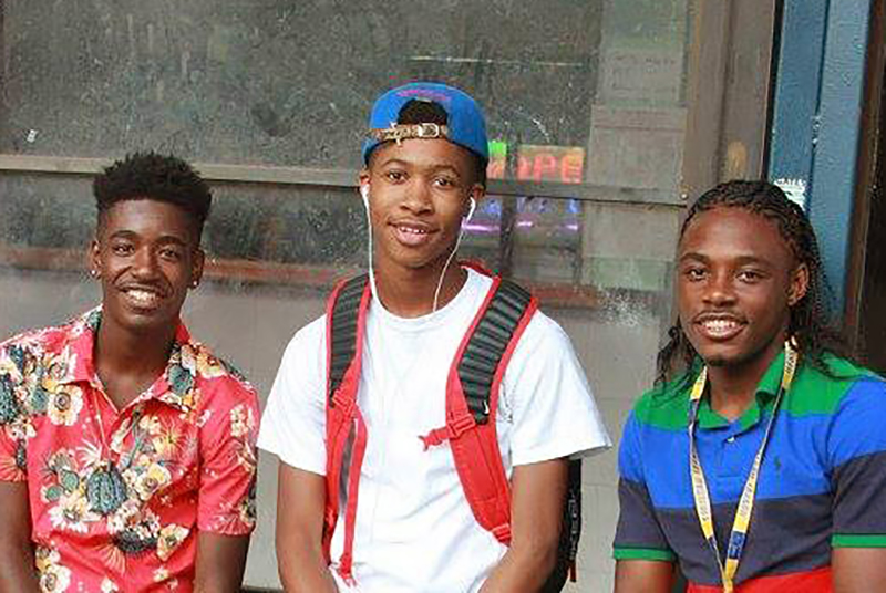 a group of three boys smiling and posing for photo
