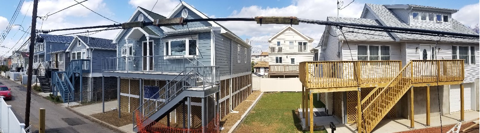 Two completed NYC Build It Back elevations next to a nearly complete elevation after a recent snow fall. 