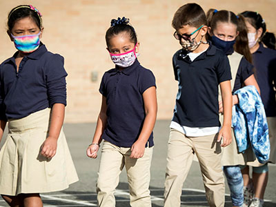 Photo of children wearing masks lining up up