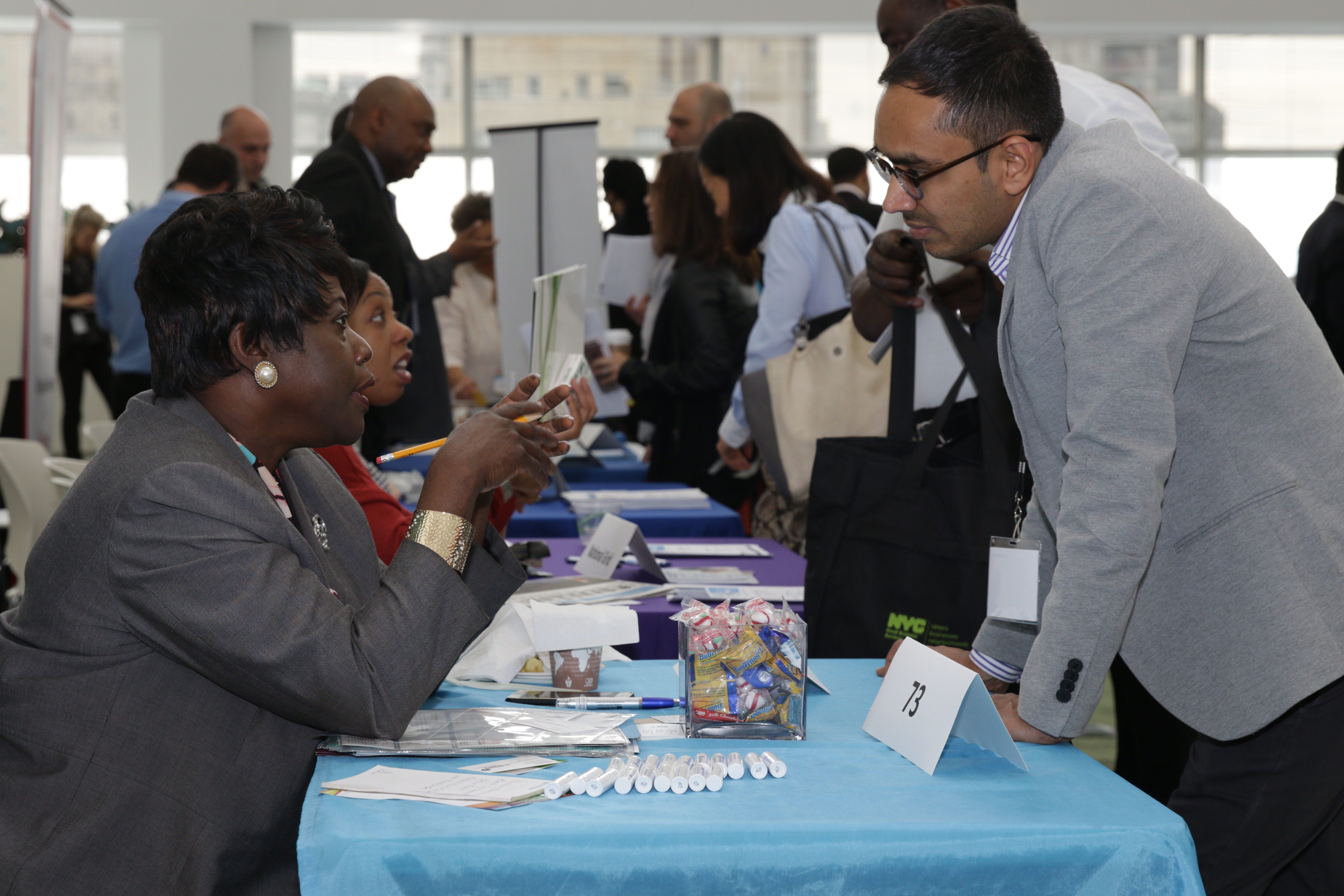 A City representative is assisting a business owner at the annual Citywide Procurement Fair