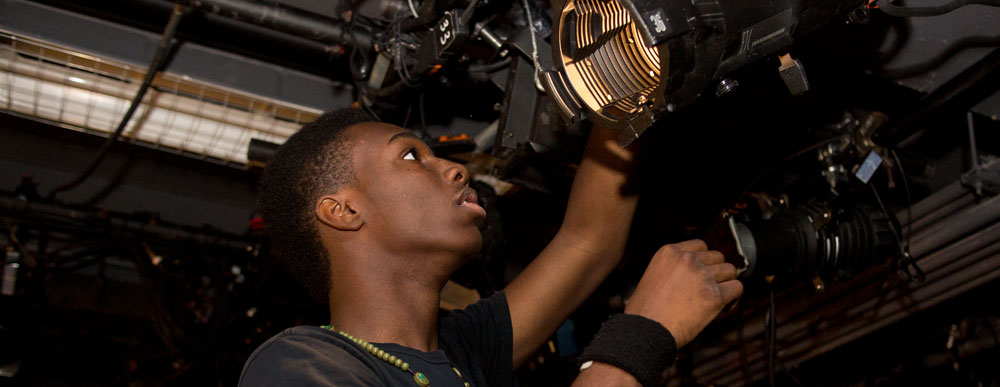 Young man adjusting lights in a theater