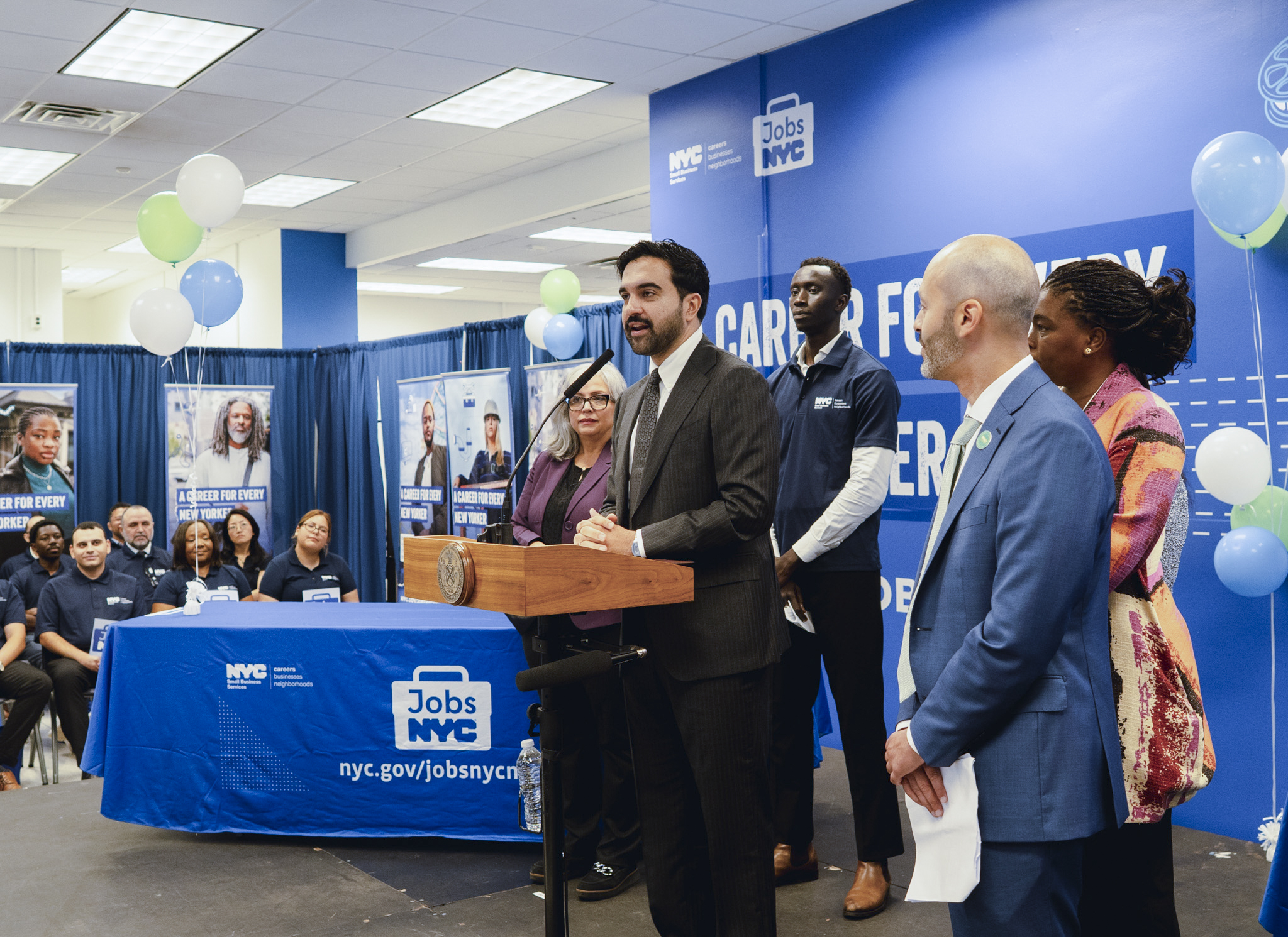 Mayor Zohran Mamdani speaking at podium during announcement of new Jobs NYC Center
                                           