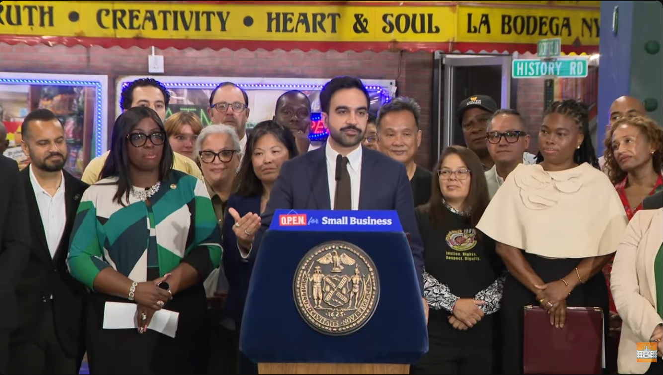 Mayor Mamdani standing in front of a large group of people making an announcement
