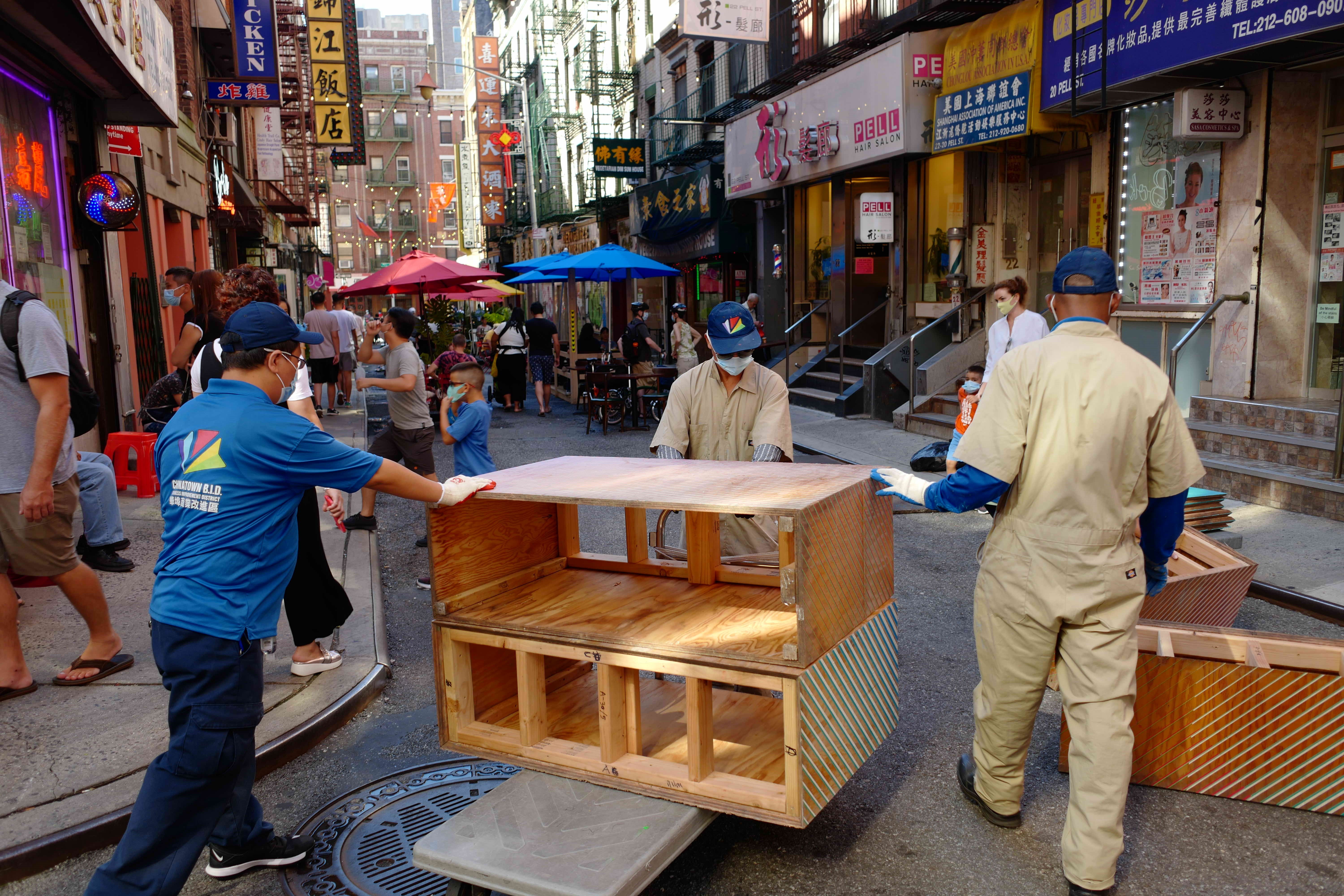 street in Chinatown with three staffers from Chinatown BID installing public seating