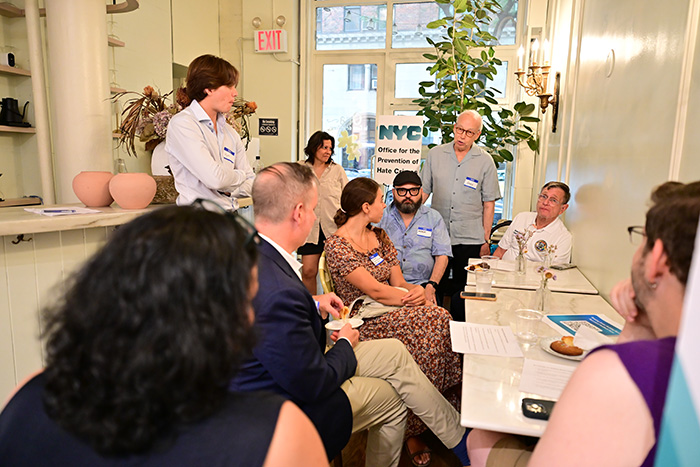 Group of guests are discussing around table at Breaking Bread Building Bonds event cohosted by OPHC and Manhattan Community Board 4.