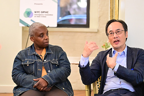 An Asian community member was speaking at BBBB event and an African American community member was listening attentively.