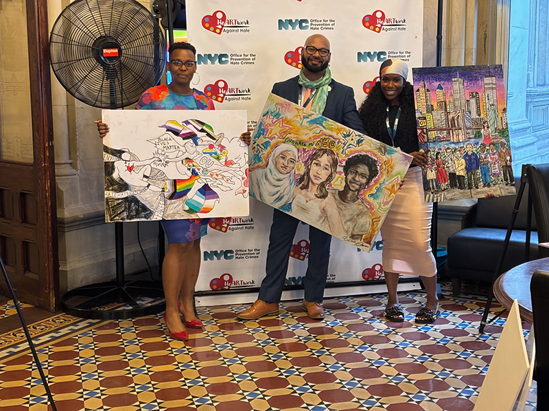 3 OPHC staff members were holding the winning artworks with smiles