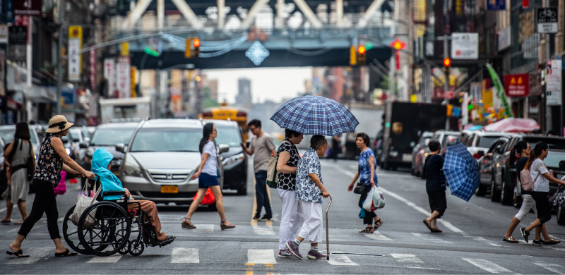 Photo of a street crossing with people crossing the street