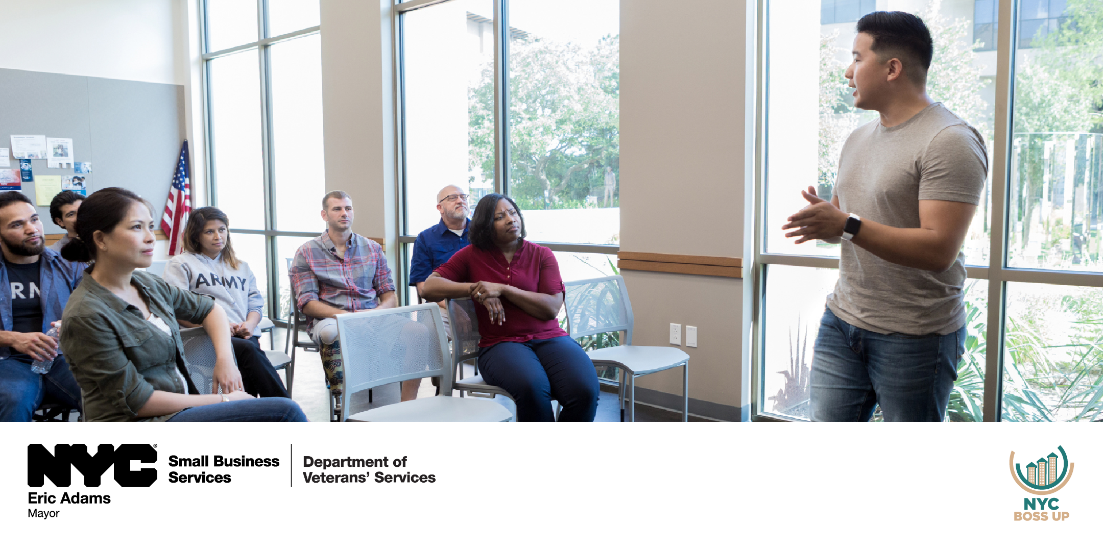 Veterans listening to a presentation in a glass walled room.
                                           