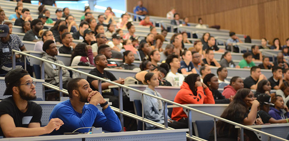 Students and youngsters at the auditorium are listening to the keynote.
                                           