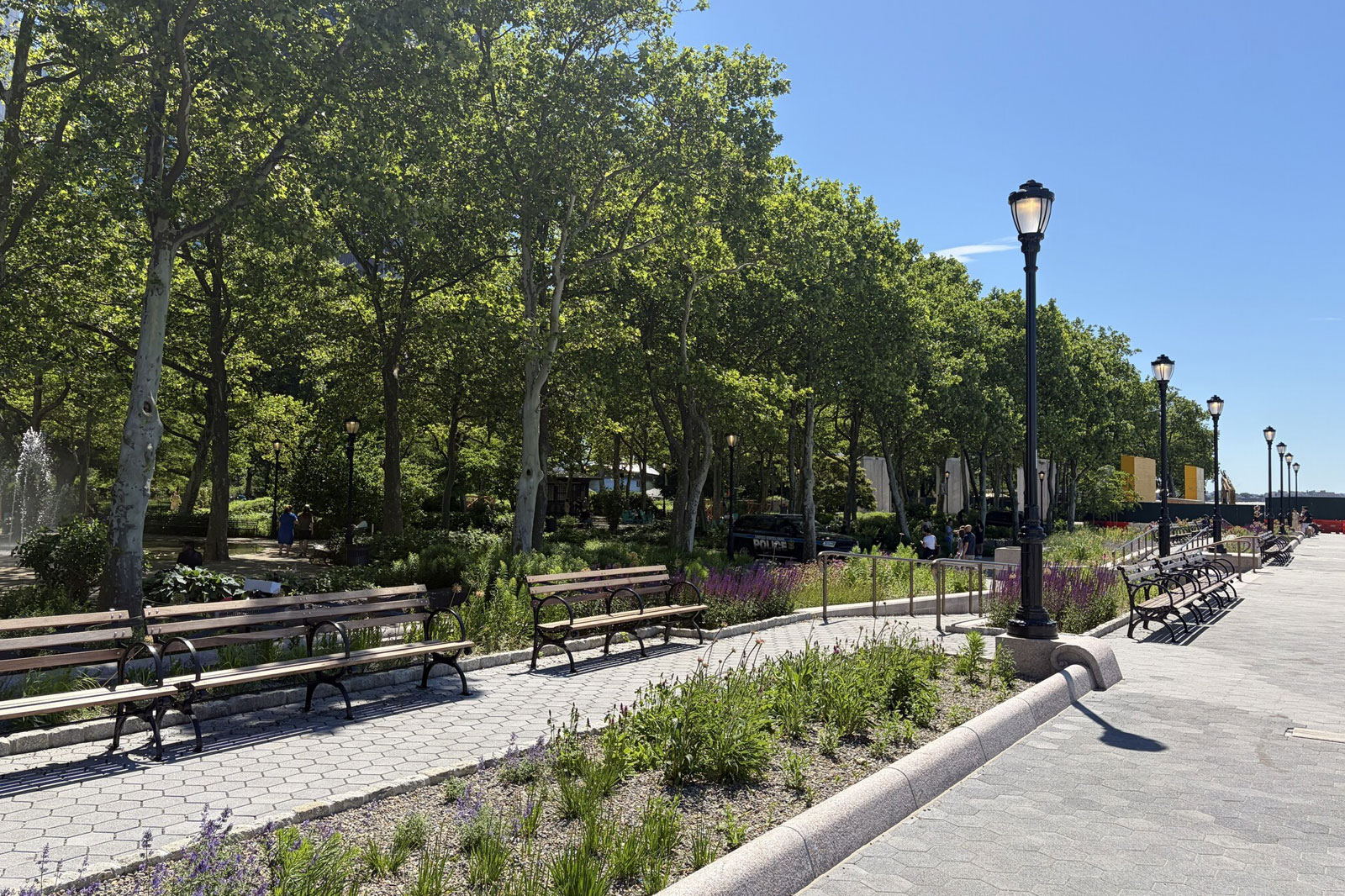 a pathway, bench chairs and street lights stretch across diagonally from bottom left to top right.