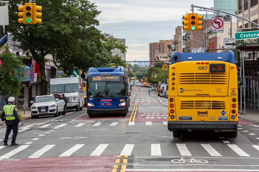 Two M T A buses travel in opposite direction along the recently activated busway on Tremont Avenue.