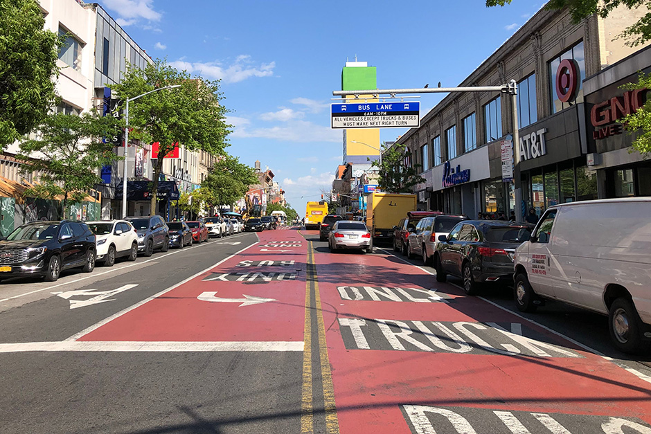 Travel lanes on a roadway are painted red and have the works Bus Truck Only painted on them.