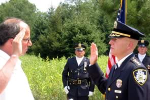 Commissioner Christopher O. Ward administers the oath of office to Edward F. Welch as Director of DEP Police.