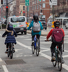 Three cyclists ride their bikes in a bike lane.