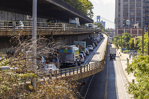 A busy three-level highway above a quiet roadway in Brooklyn