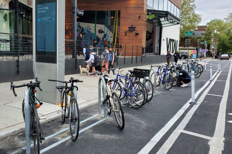 A bike corral in Brooklyn, made up of multiple bike racks in the roadway next to the curb.