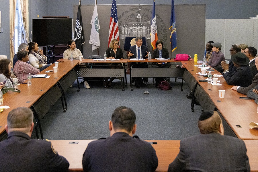 Commissioner Rodriguez sites around a large table meeting with community members and elected officials on Staten Island